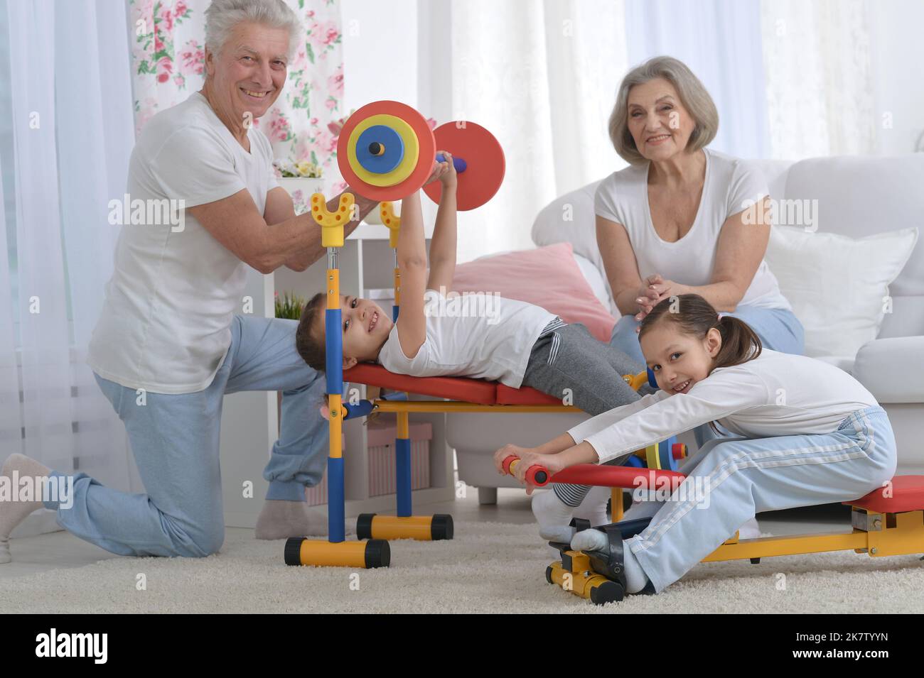 Großvater und Großmutter trainieren zusammen mit ihren Enkelinnen Stockfoto