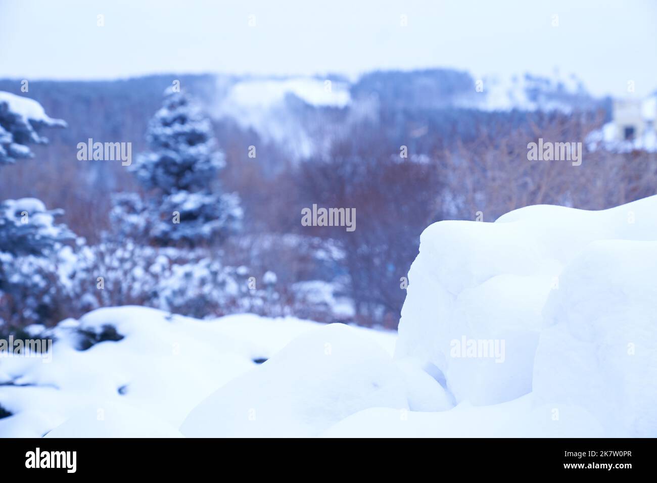 Ein Podium aus Schnee für Ihr Produkt vor dem Hintergrund einer Winterlandschaft. Nahaufnahme von Schnee und verschwommenem Hintergrund, Mockup und Display für Weihnachtsgeschenk. Hochwertige Fotos Stockfoto