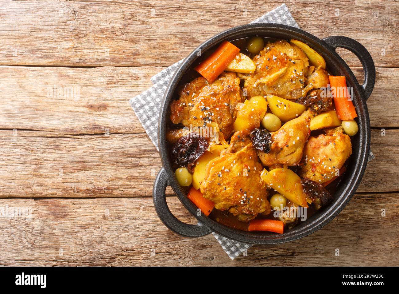 Gallo en Chicha ist ein Hahn, der in einem fermentierten Maisgetränk mit Gemüse und Gewürzen in der Pfanne auf dem Holztisch zubereitet wird. Horizontale Ansicht von oben fr Stockfoto