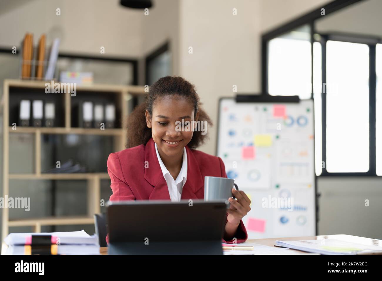 Lächelnd afro Geschäftsfrau am Laptop arbeiten in modernen Büro Stockfoto