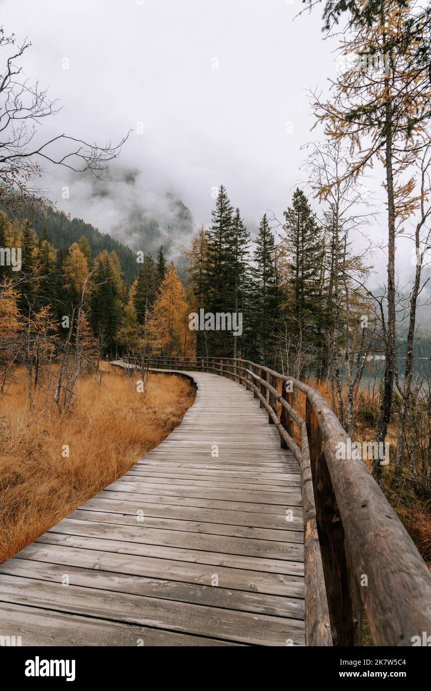 Wanderweg / Holzsteg am Antolzer See in den Dolomiten. Herbstliche Landschaft am See in Südtirol. 2 Stockfoto