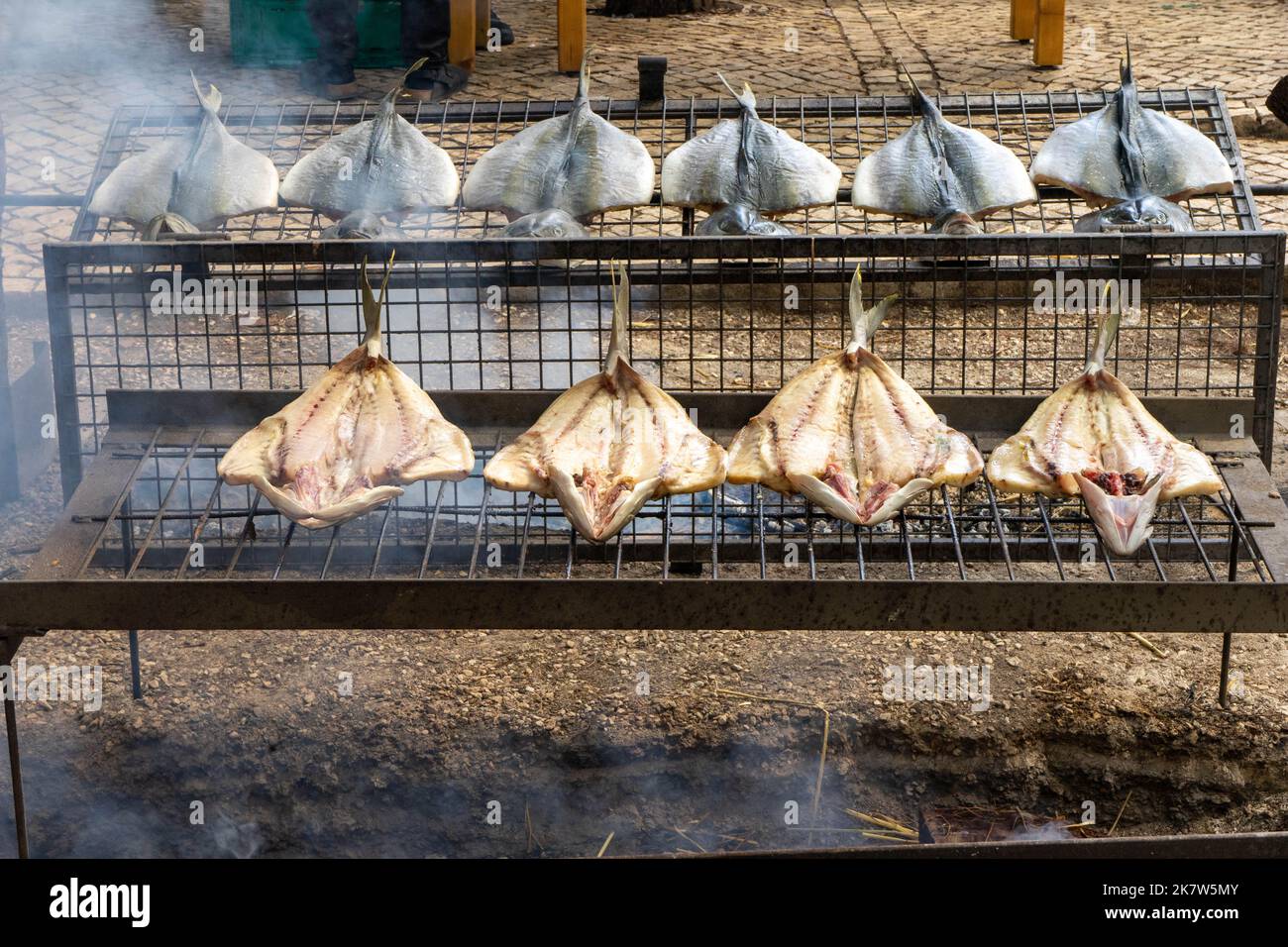 Verschiedene Fischarten, die auf einem Lebensmittelfest in Estoril über einem Feuer gekocht werden, Stockfoto