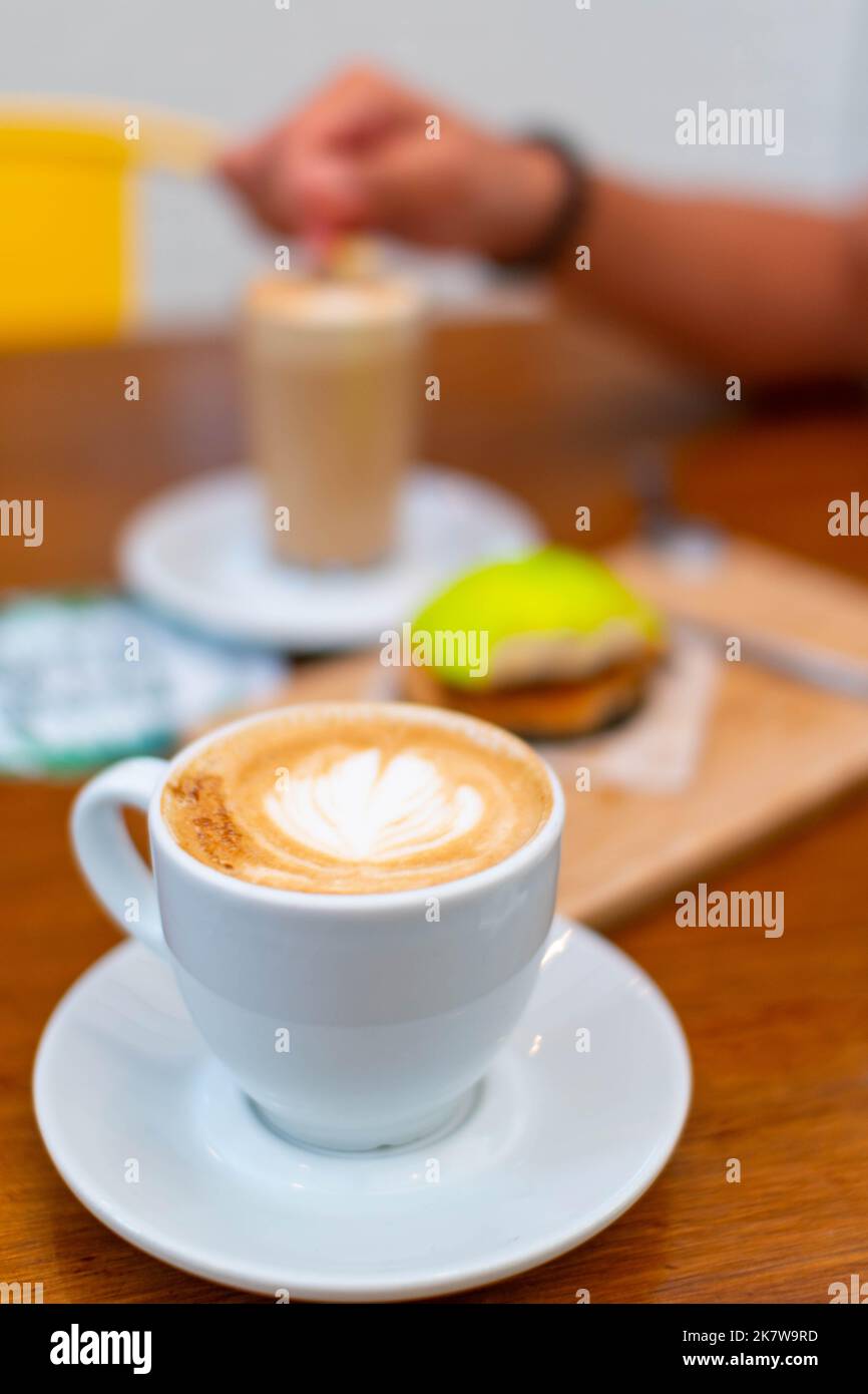 Ein Tisch in einer Bar. Es gibt zwei Kaffees und eine Torte Stockfoto