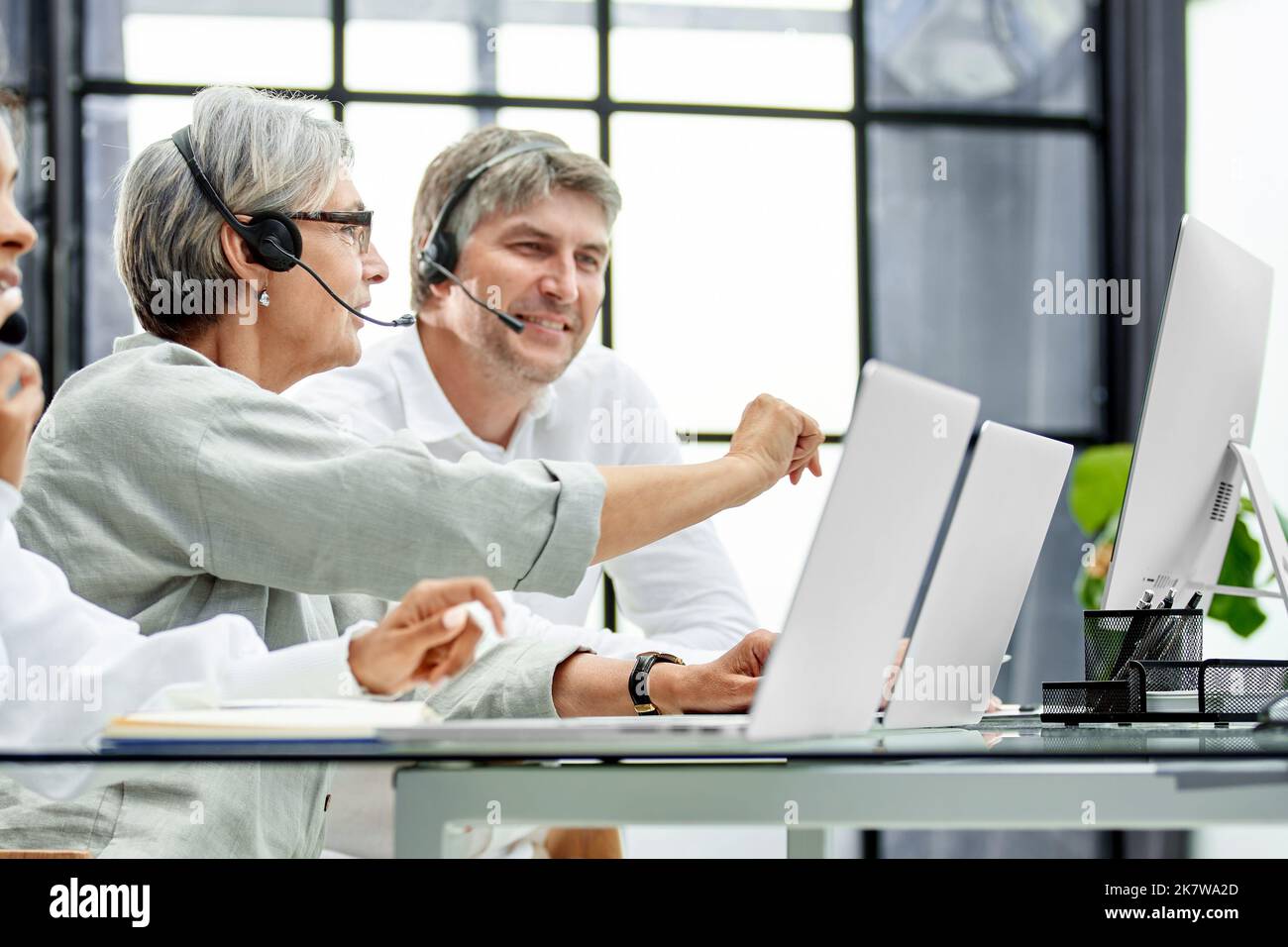 Call Center-Agent mit Headset arbeitet an der Support-Hotline im modernen Büro. Stockfoto