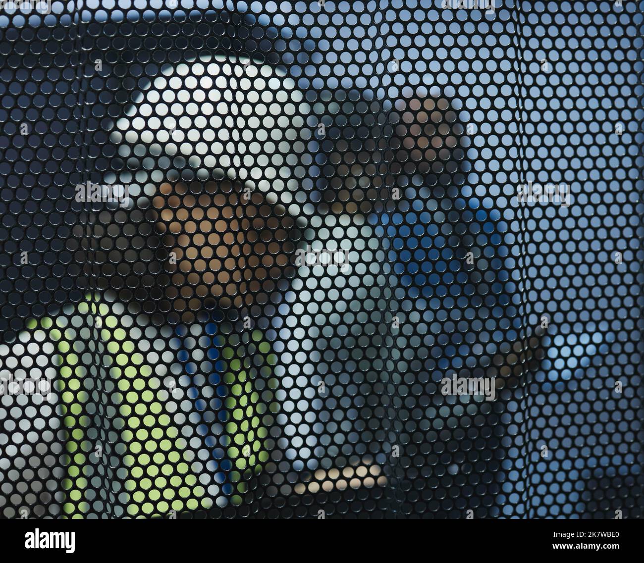 Kein Stein blieb ungewendet. Eine junge Frau, die ihre Notizen bei der Arbeit hinter einem Bildschirm überprüft. Stockfoto