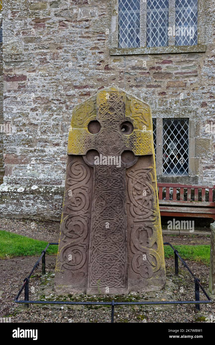 The West View of the Aberlemno 2 Sculptured Stone im Kirkyard der örtlichen Kirche, mit seinem keltischen Kreuz in einer roten Sandsteinplatte geschnitzt. Stockfoto