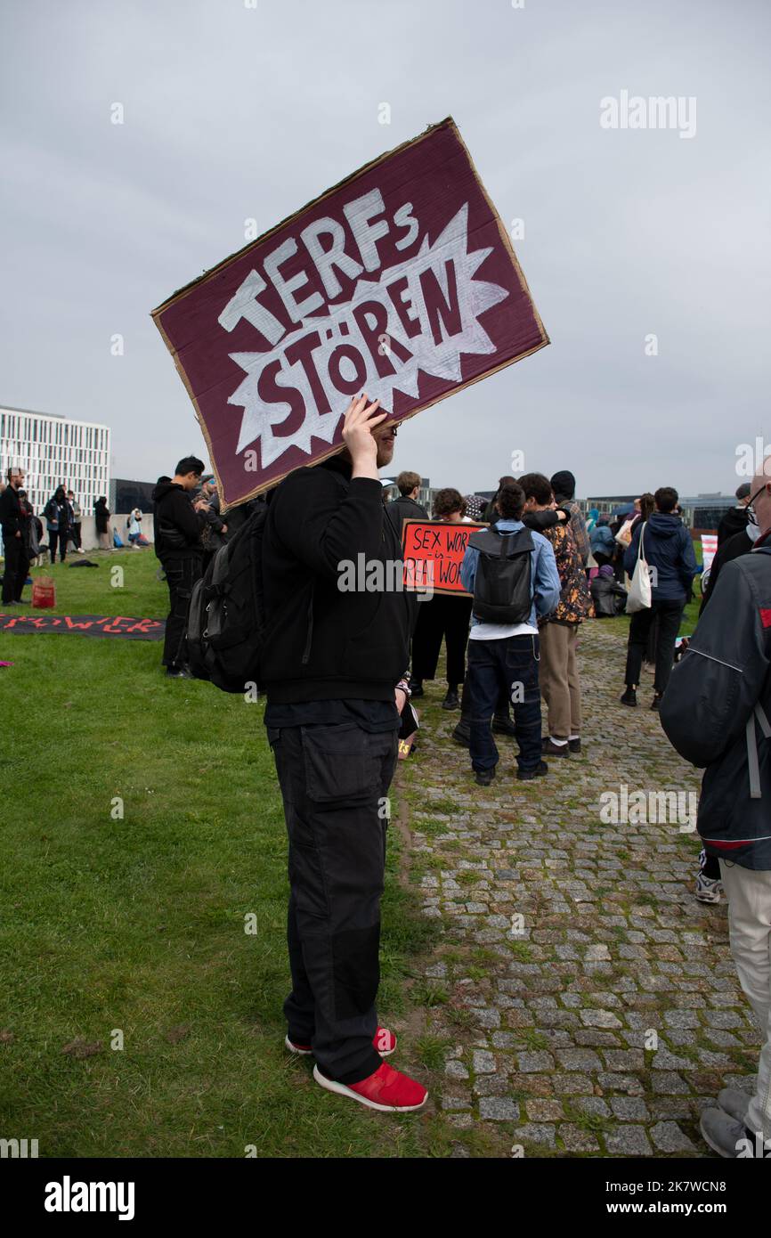 Ein Transgender-Protestler hält bei einer Demonstration gegen Terfs in Berlin ein "Terfs Stören"-Zeichen hoch Stockfoto