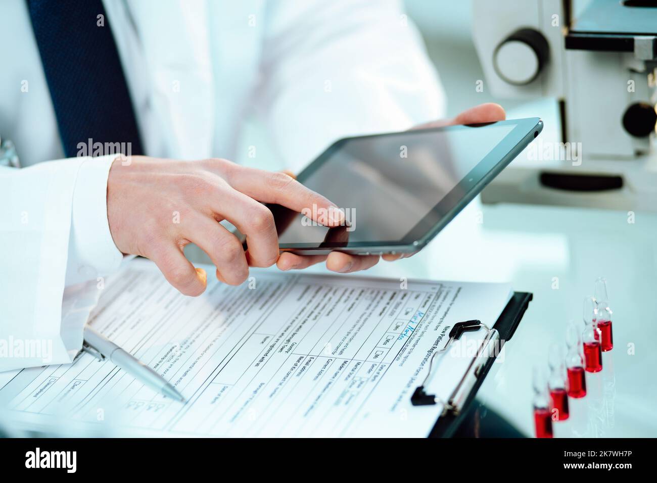 Wissenschaftler arbeiten an einem Tablet und gehen über Forschungsnotizen. Stockfoto