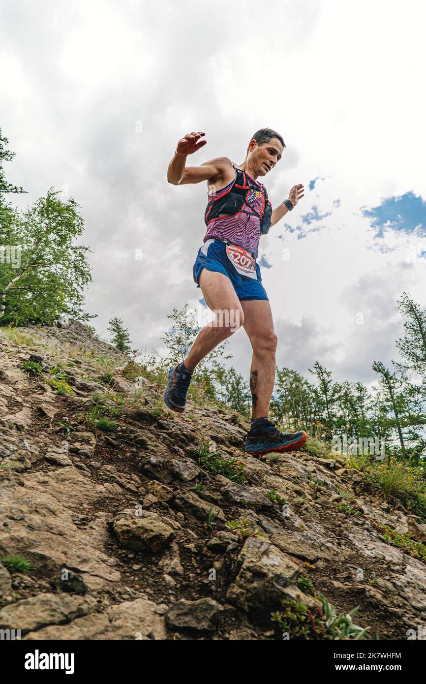 Bannoe, Russland - 31. Juli 2022: Mann-Läufer laufen steilen Bergabstieg im MMK Wild Trail Stockfoto