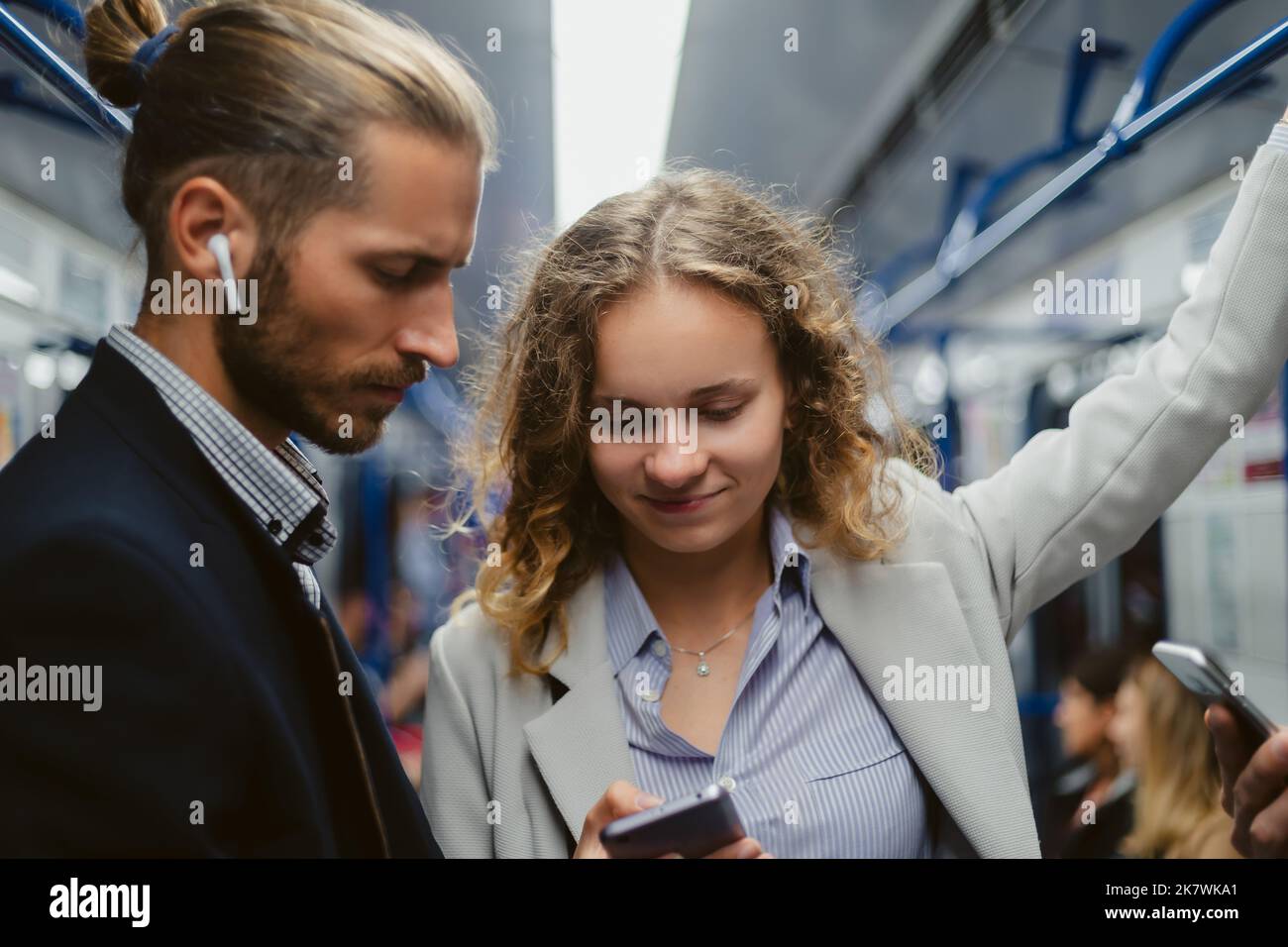Nahaufnahme . Junge Menschen mit Smartphones fahren in einem U-Bahn-Auto. Stockfoto