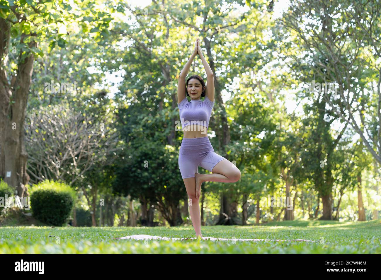 Portrait of happiness junge Frau praktiziert Yoga im Freien.Yoga und Relax Konzept. Schönes Mädchen Praxis Asana Stockfoto