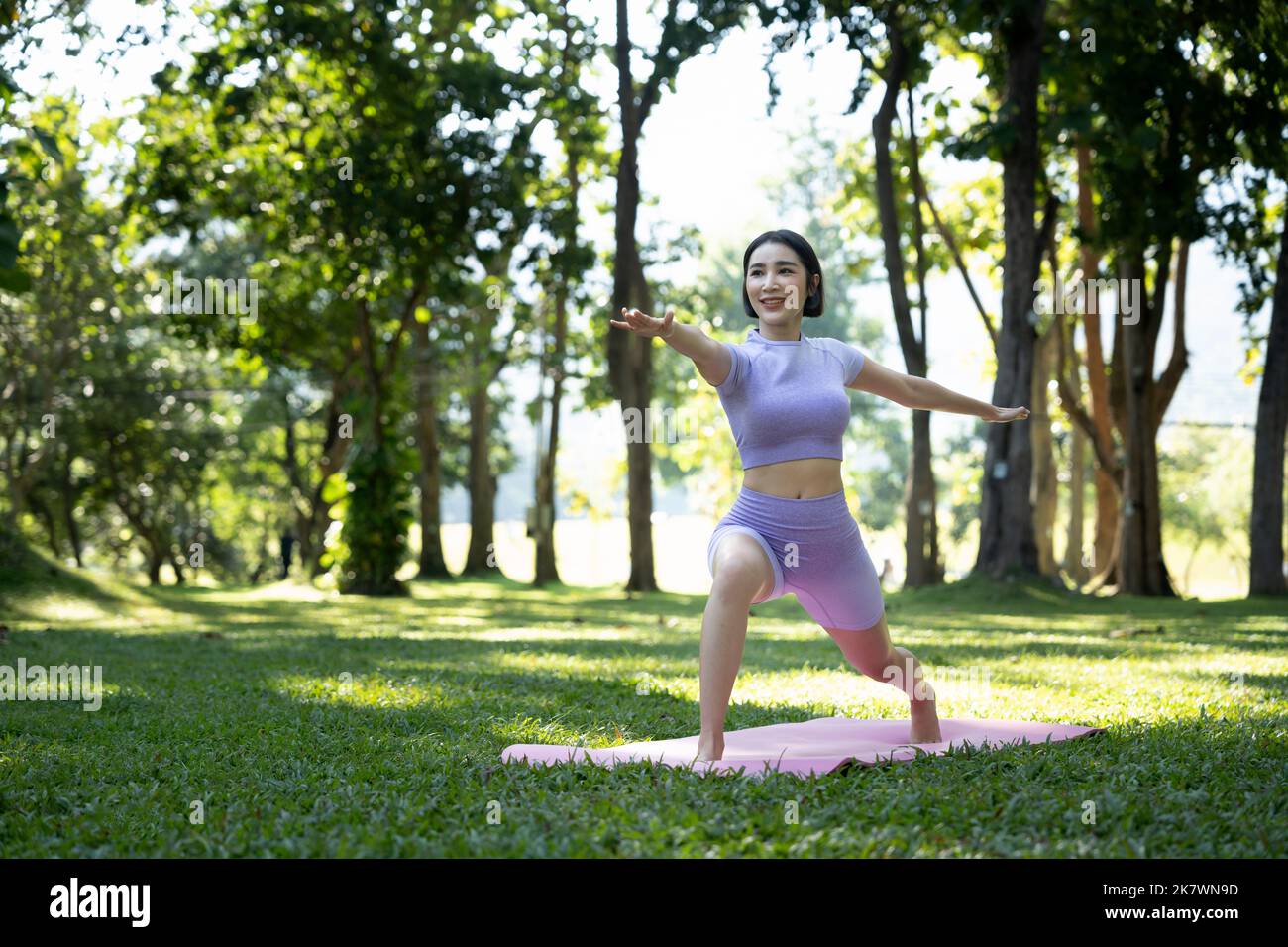 Porträt einer jungen Frau, die im Garten Yoga macht, um ein Workout zu machen. Konzept des Lebensstils Fitness und gesund. Asiatische Frauen üben Yoga in der Stockfoto