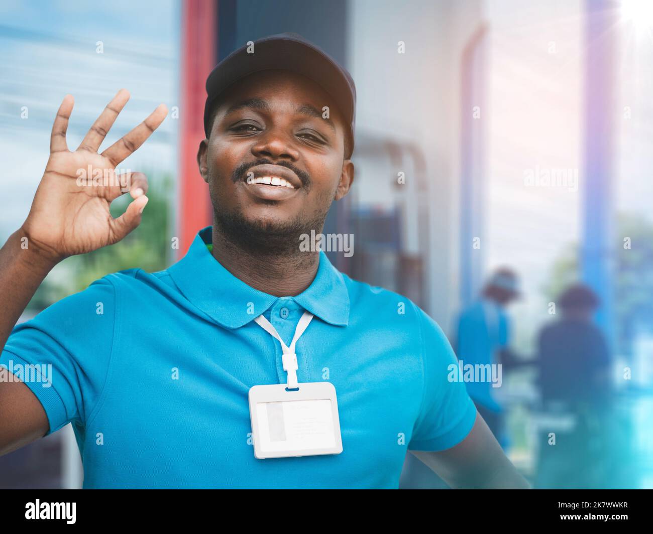 Uniform african man Tankstelle Arbeiter tanken ein Auto. Tankstellenmitarbeiter füllen mit einem Lächeln Kraftstoff in das Auto Stockfoto