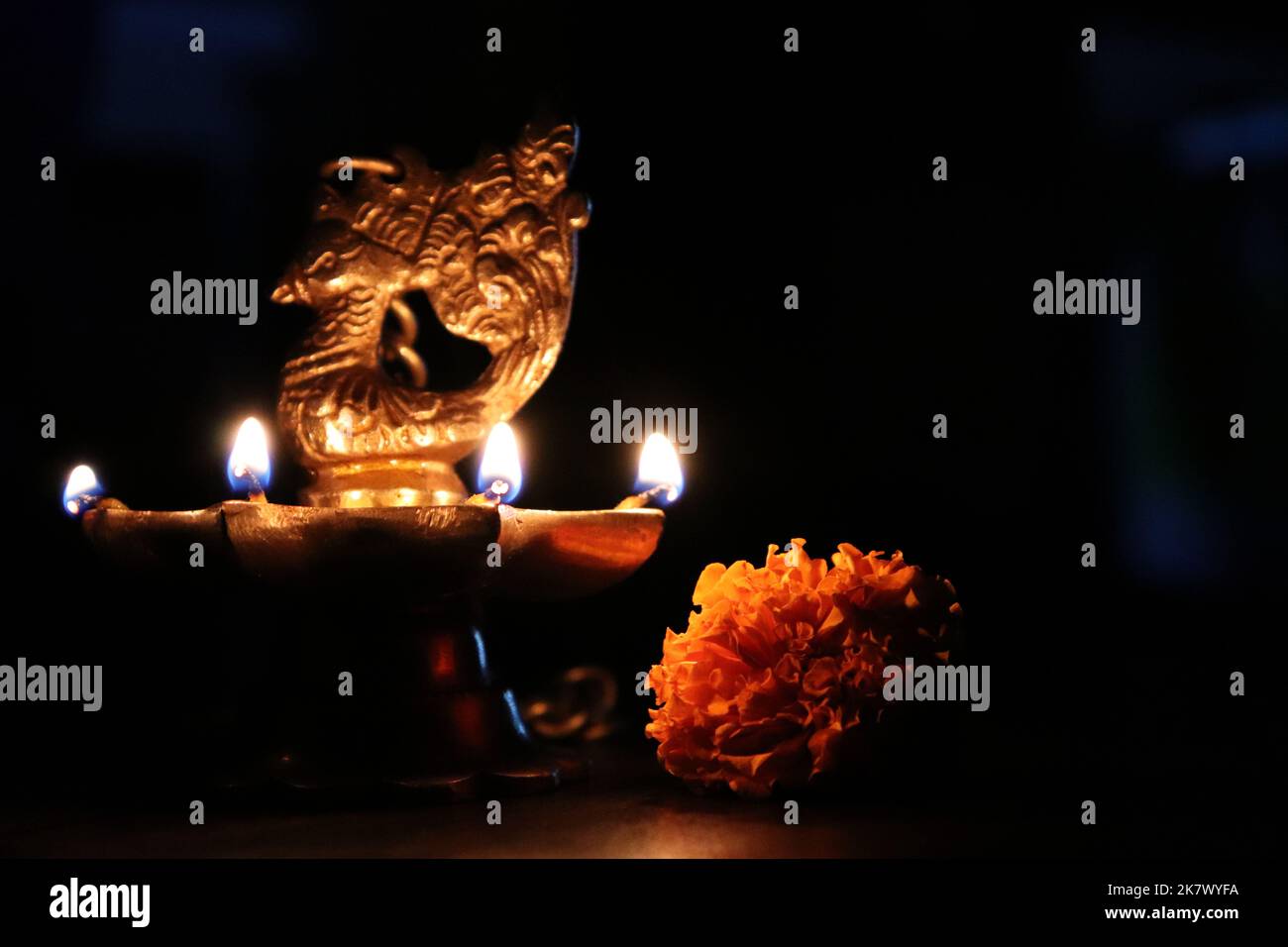 Brennende Pfauenöl-Lampe aus Messing/Ringelblume gegen Bokeh/Diwali/Deepavali-Festival Stockfoto