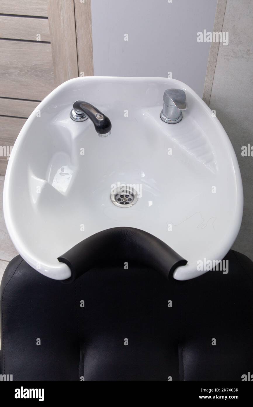 Professionelles weißes Waschbecken im Inneren eines Schönheitssalons. Barbershop Waschbecken, moderner Friseur und Friseursalon, Barbershop für Männer. Stockfoto