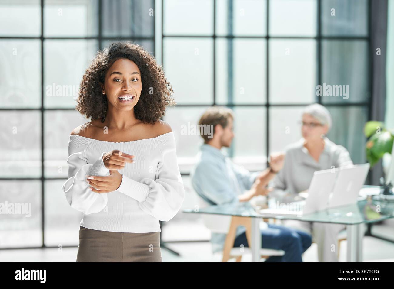 Enthusiastische Geschäftsfrau, die im Büro steht. Stockfoto