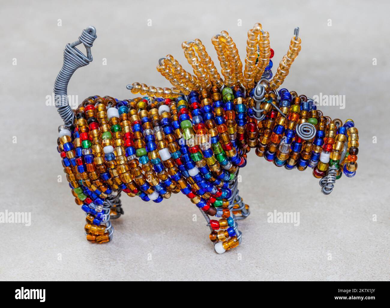 Bunte südafrikanische Perlen Handwerk von Warzenschwein auf meliertem Grau mit Kopierer Platz Stockfoto