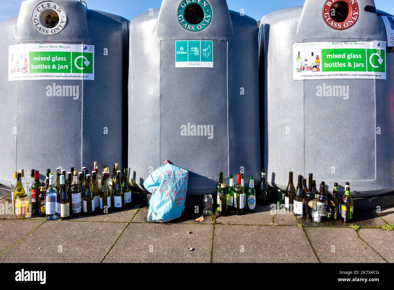 Flaschen- und Glasbänke drei volle Behälter und Weinbotllen, viele mit Verschlüssen, die außerhalb der Behälter angeordnet sind Stockfoto