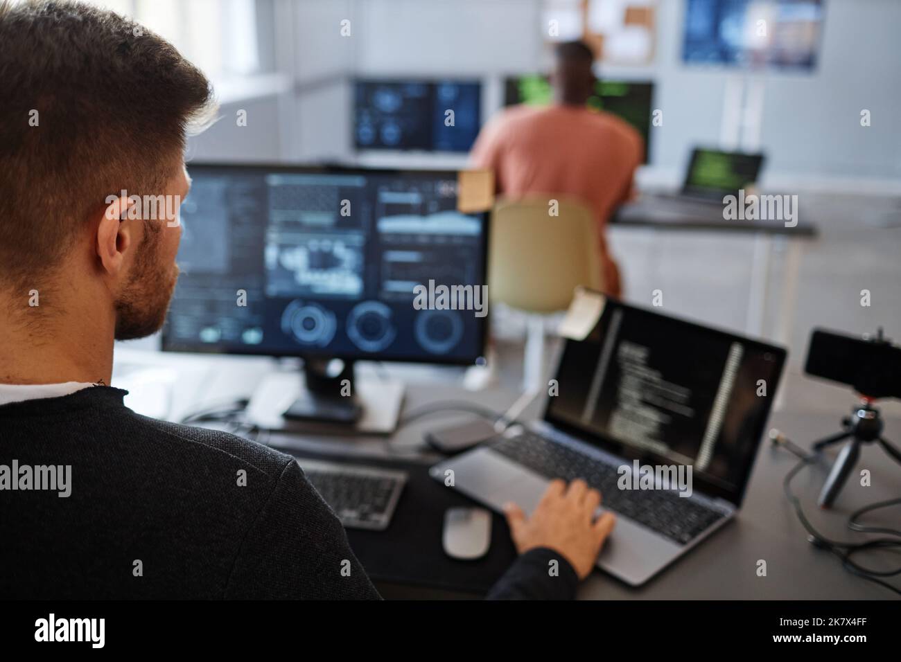 Nahaufnahme eines männlichen Software-Ingenieurs, der Computer im Büro mit Datensystemen auf dem Bildschirm verwendet, Kopierraum Stockfoto