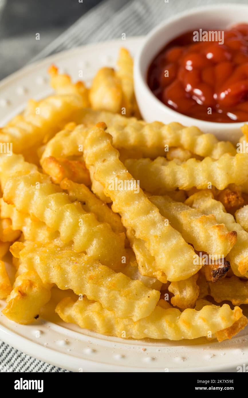 Hausgemachte Crinkle Cut Pommes mit Ketchup Stockfoto