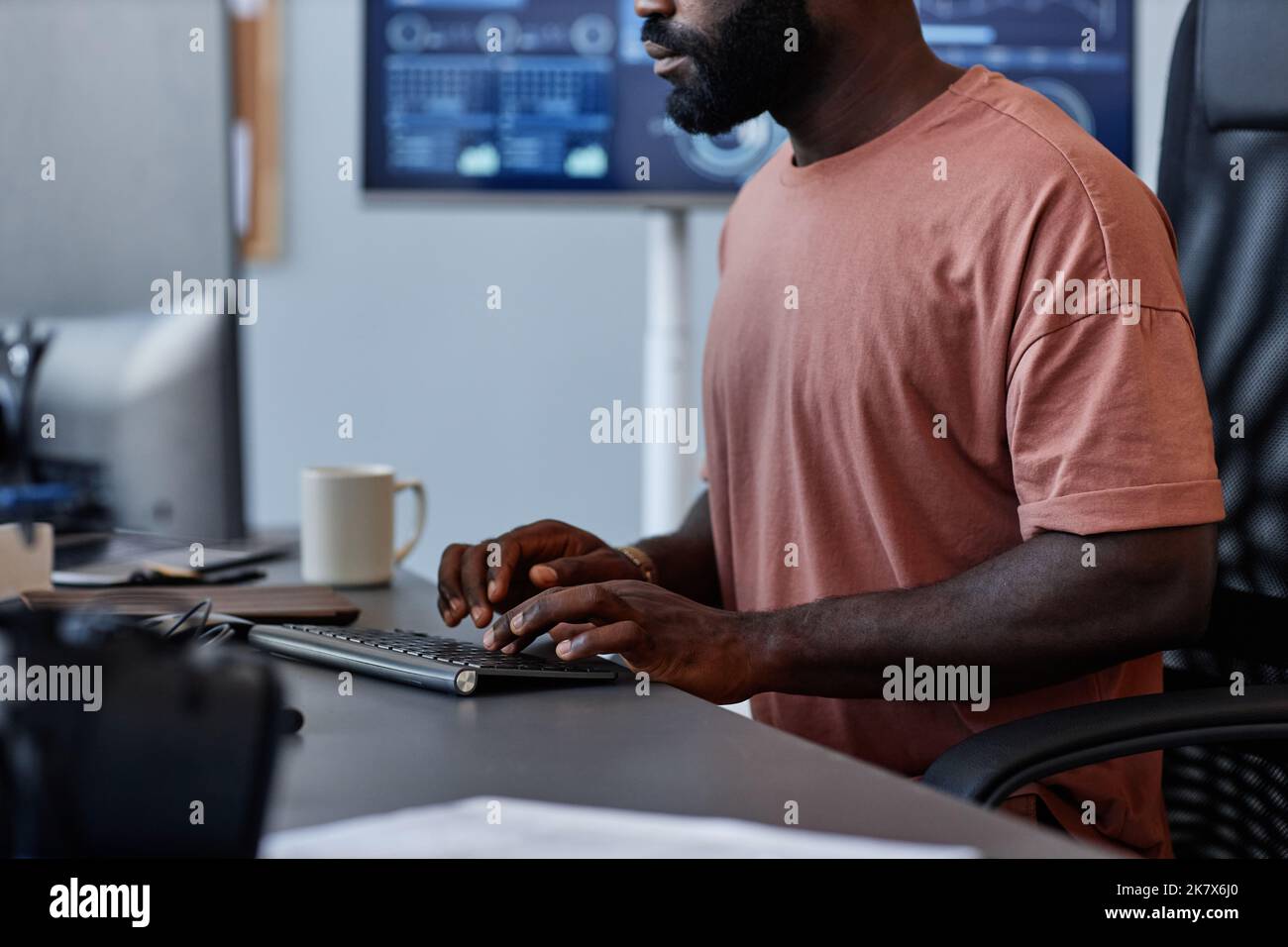 Eine kurze Aufnahme eines schwarzen Mannes als Softwareentwickler, der Computer im High-Tech-Büro verwendet Stockfoto