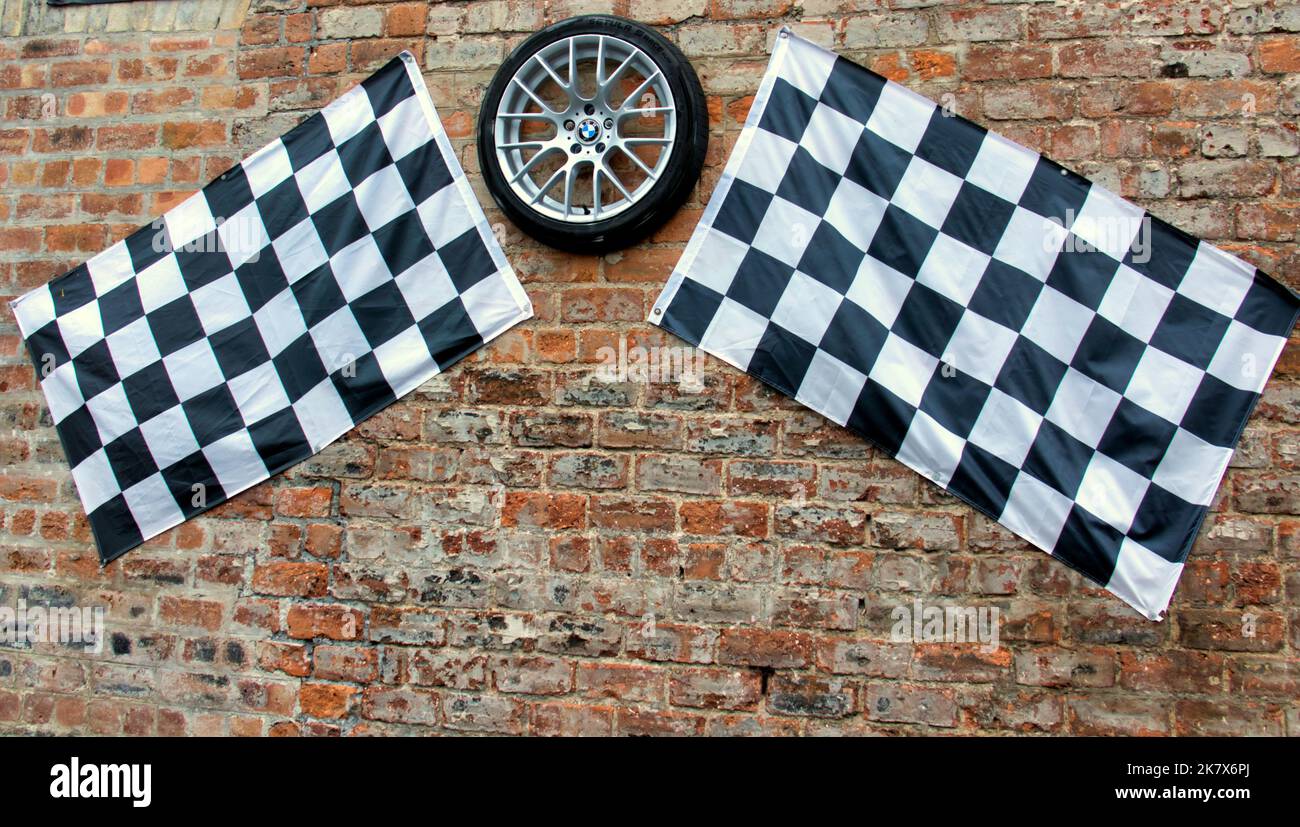 Karierte Flagge mit Garagenwand mit BMW-Rad und Reifen Stockfoto