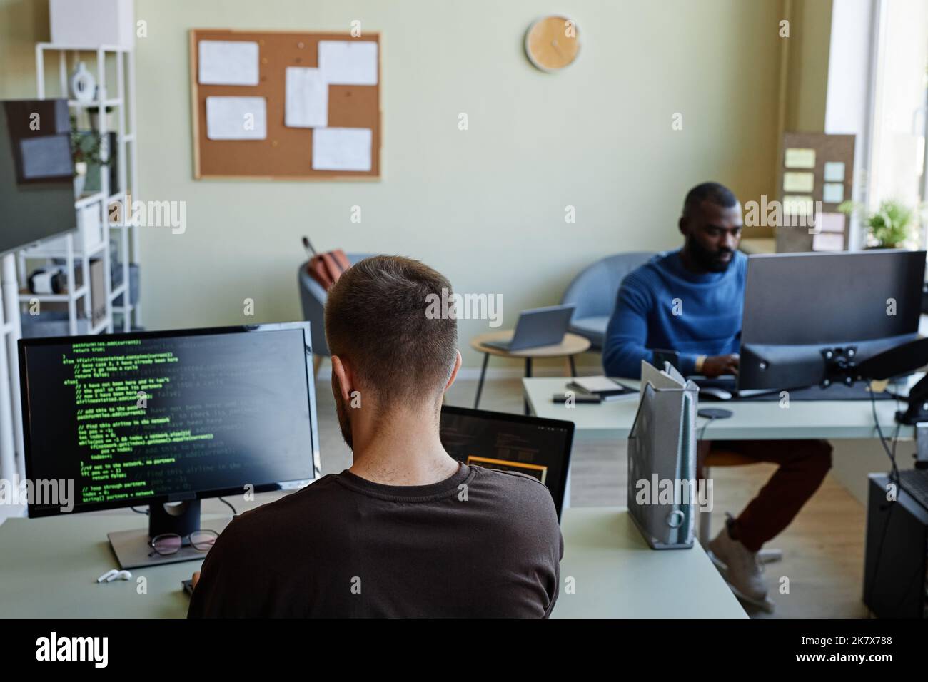 Hintergrundbild des IT-Büros mit Mann, der Code in grünen Linien schreibt, Kopierraum Stockfoto
