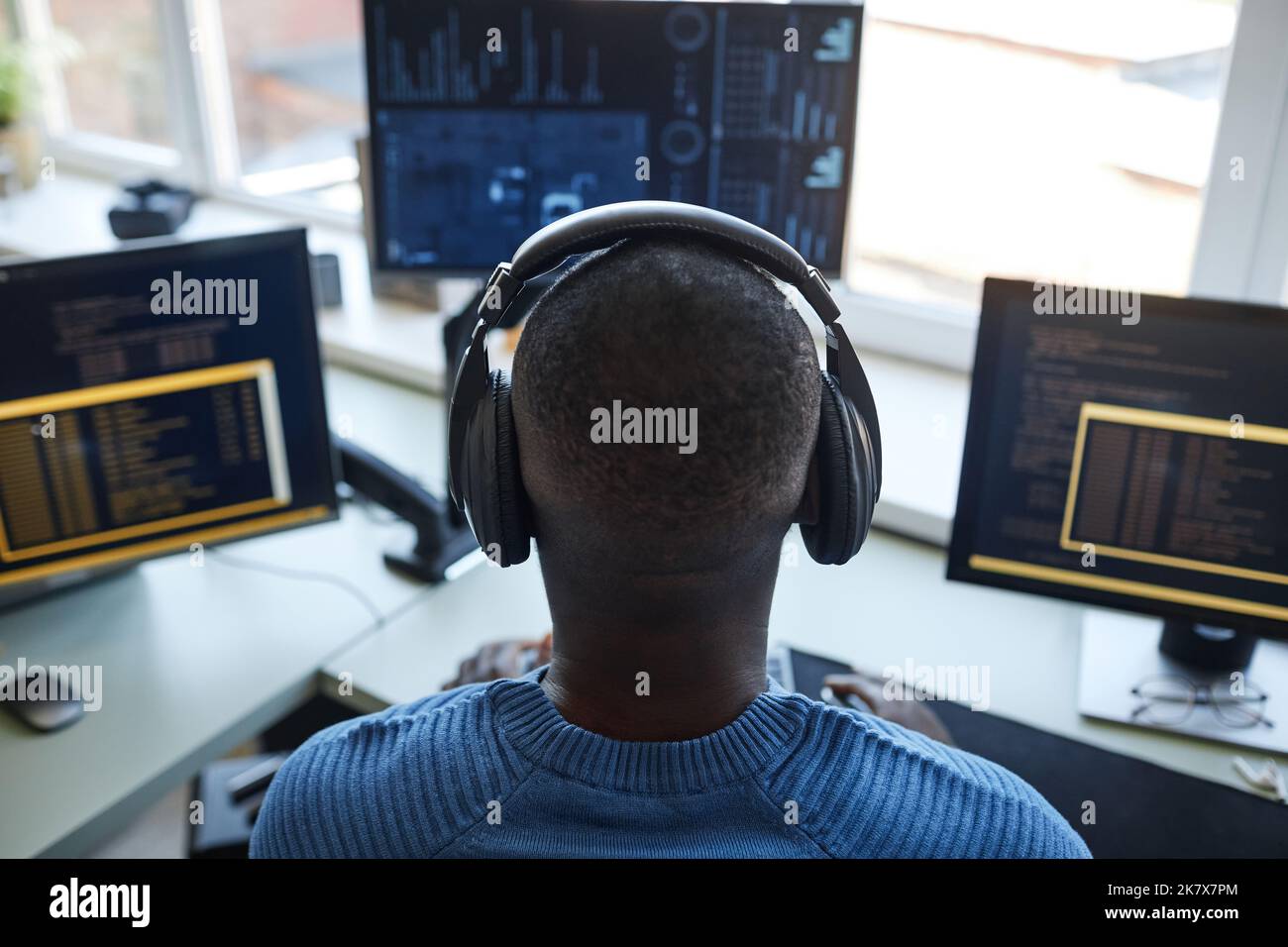 Rückansicht Porträt des Softwareentwicklers auf der Workstation mit mehreren Computerbildschirmen Stockfoto