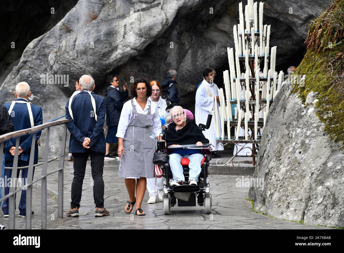 Lourdes, Hautes-Pyrénées, Frankreich. Betreuer mit Pilger im Rollstuhl Stockfoto