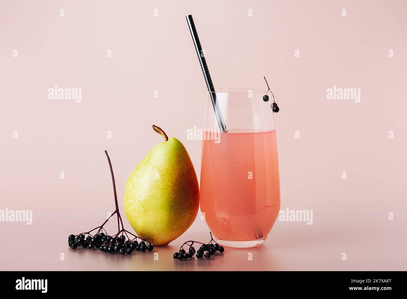 Holunderdrink, Cocktail mit Birne auf farbigem Hintergrund. Stockfoto