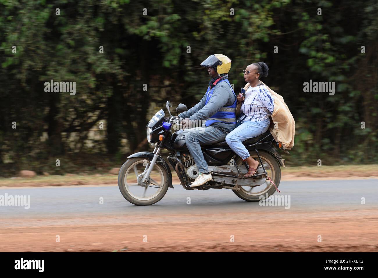 Ein Sozius, der auf Motorradtaxis fährt, bekannt als Boda Boda, in Ostafrika. Boda bodas sind ein wichtiger Teil des Verkehrsnetzes und werden genutzt Stockfoto