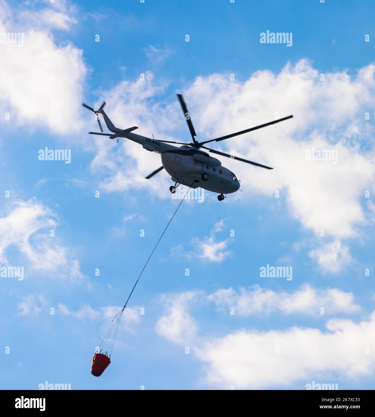 Helikopter fliegt in den Himmel und gießt Wasser auf Feuer. Gesehen auf der insel rhodos, Griechenland. Stockfoto