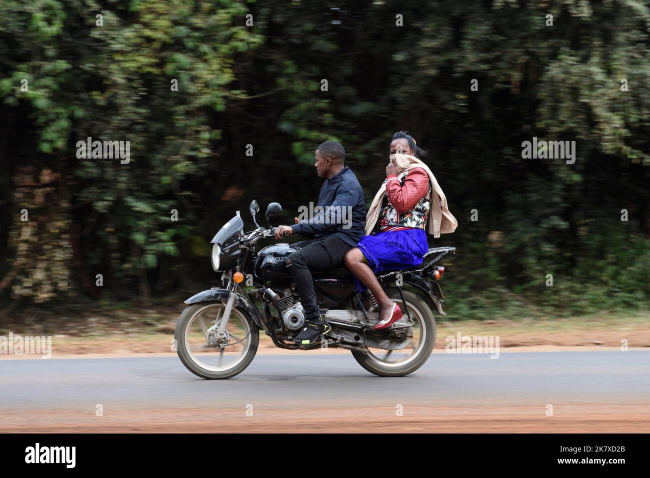 Ein Sozius, der auf Motorradtaxis fährt, bekannt als Boda Boda, in Ostafrika. Boda bodas sind ein wichtiger Teil des Verkehrsnetzes und werden genutzt Stockfoto