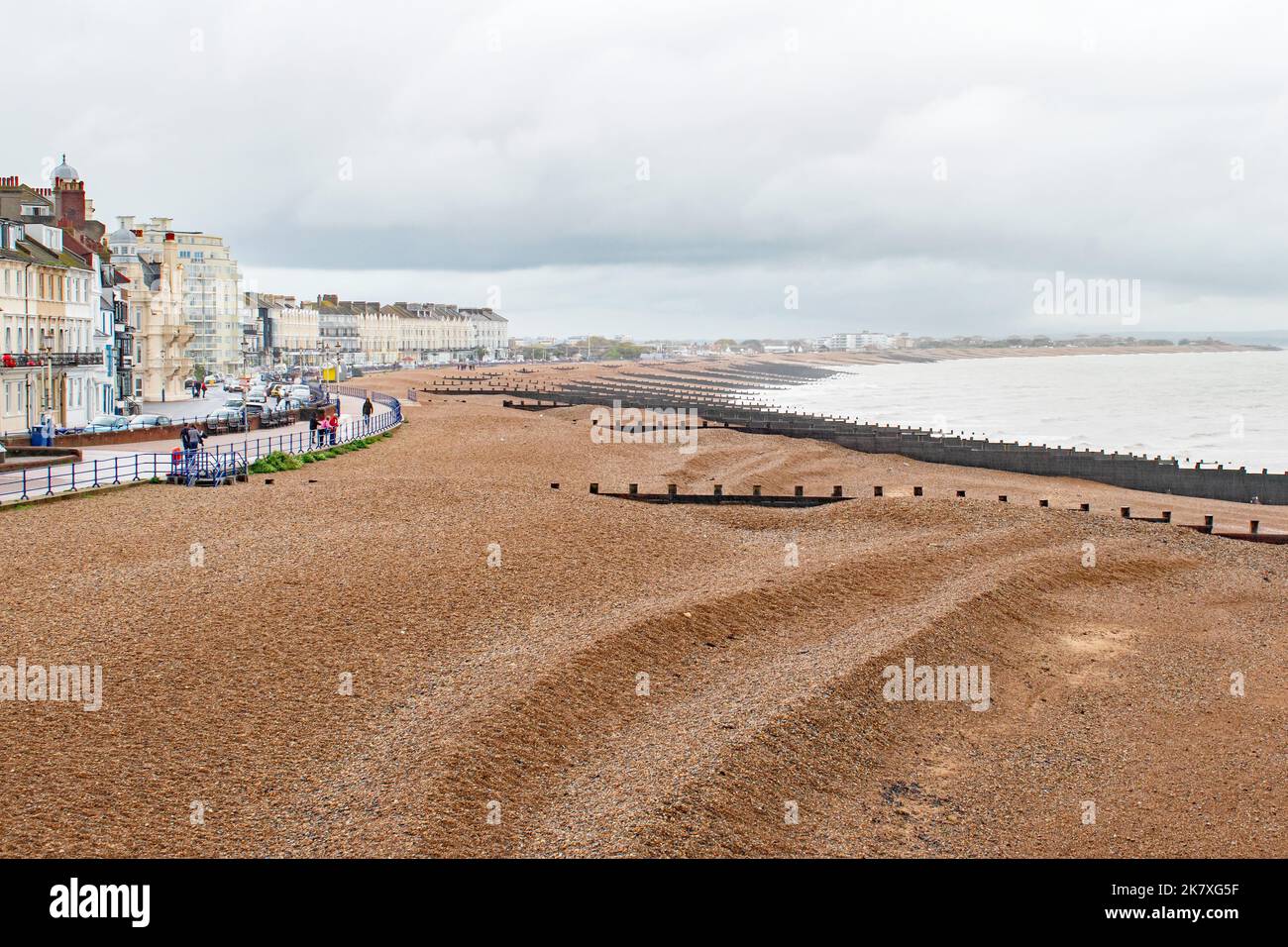 Ein nasser Oktobermorgen an der Strandpromenade von Eastbourne mit Blick auf den leeren, groynes Holzstrand Stockfoto