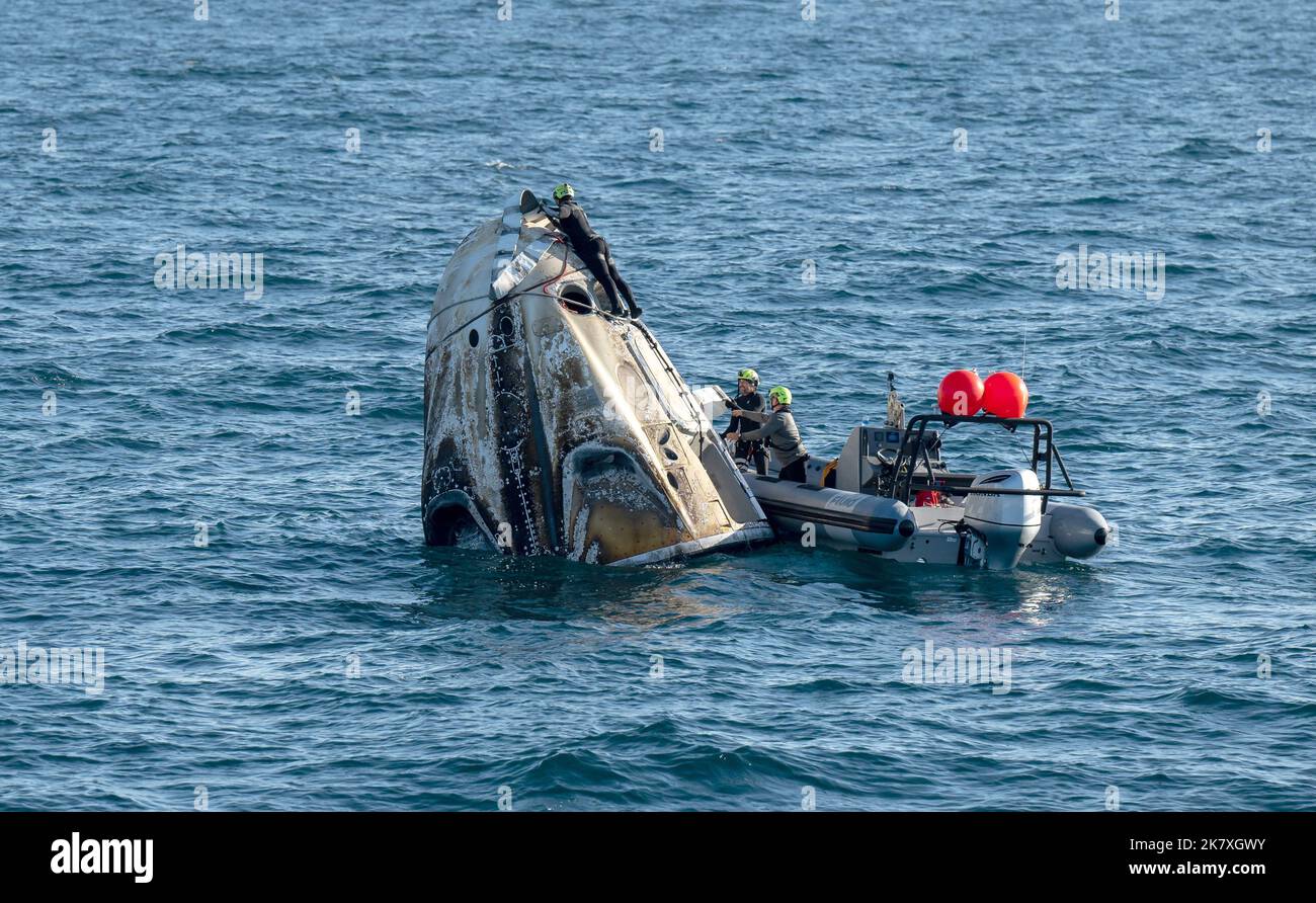 Support-Teams arbeiten um die Raumsonde SpaceX Crew Dragon Freedom, kurz nachdem sie mit den NASA-Astronauten Kjell Lindgren, Robert Hines, Jessica Watkins und der ESA-Astronautin Samantha Cristoforetti an Bord im Atlantik vor der Küste von Jacksonville, Florida, gelandet ist, am Freitag, den 14. Oktober 2022. Stockfoto