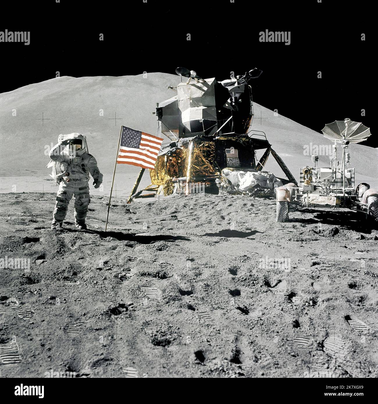 Die Apollo-15-Astronauten Jim Iwrin und David Scott stellten das erste Lunar Roving-Fahrzeug auf den Mond. Während ihres 67-stündigen Aufenthalts nutzten sie den Rover, um drei separate Fahrten über den Landeplatz Hadley-Apennin zu Unternehmen. Hier begrüßt Irwin die amerikanische Flagge, während er neben der Mondlandefähre und dem Rover steht. Stockfoto