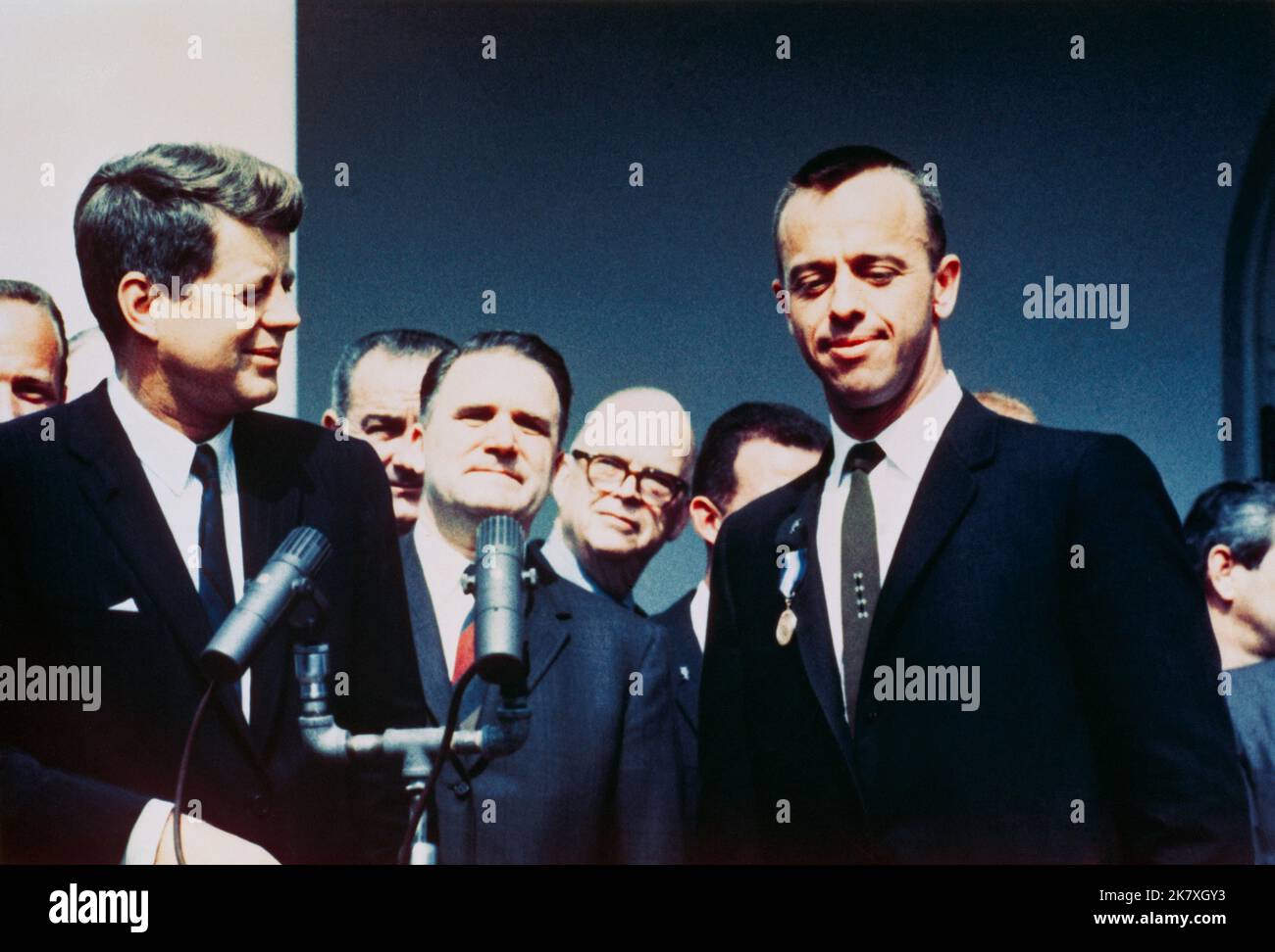 Präsident John F. Kennedy überreicht den Astronauten Alan B. Shepard Jr. bei einer Zeremonie im Rosengarten am 8. Mai 1961 im Weißen Haus mit dem Distinguished Service Medal Award der NASA. Vizepräsident Lyndon B. Johnson, NASA-Administrator James E. Webb und mehrere NASA-Astronauten stehen im Hintergrund. Nur drei Wochen später würde Kennedy Amerika verpflichten, vor dem Ende des Jahrzehnts einen Mann auf dem Mond zu landen. Bild: NASA Stockfoto
