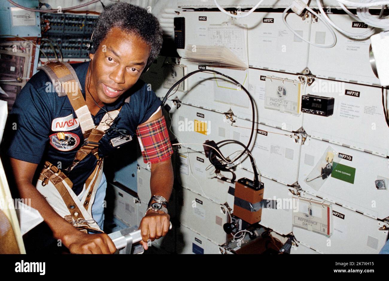 Auf dem Middeck des Challengers unterstützt der Missionsspezialist Guion 'Guy' Bluford Dr. William E. Thornton (außer Rahmen) bei einem medizinischen Test, der die Verwendung des Laufband-Trainingsgeräts erfordert, das am 5. September 1983 vom Arzt der STS-8 für die Raumfahrt entwickelt wurde. Die vorderen Schließfächer mit Datenaufzeichnungseinheiten und Checklisten-Notizbüchern befinden sich links von Bluford. Guy Bluford war der erste afroamerikanische Astronaut, der ins All flog. Stockfoto