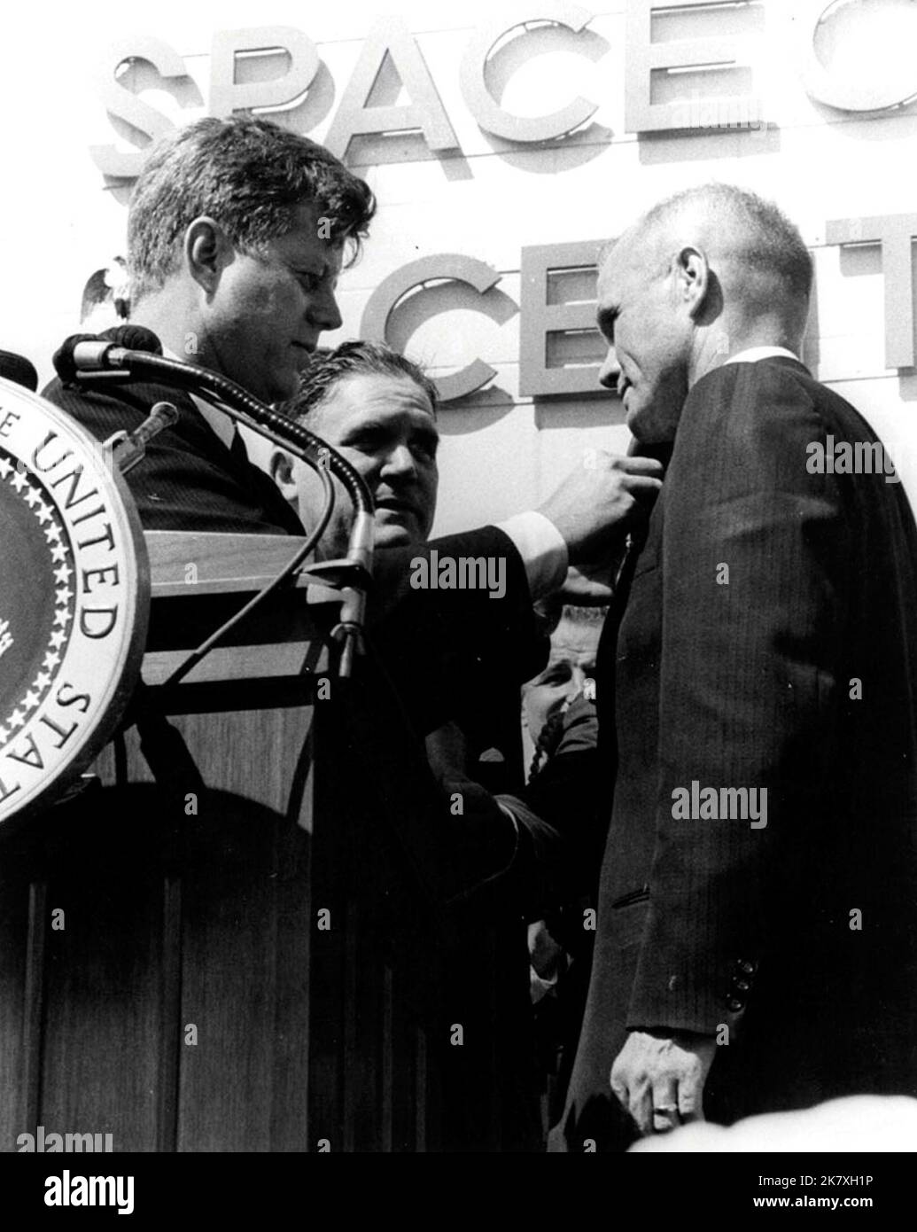 Präsident John F. Kennedy stiftet nach seinem historischen drei-Orbit-Flug, Mercury-Atlas 6, eine NASA Distinguished Service Medal auf den Astronauten John Glenn Jr. Die Zeremonie fand vor dem Hangar S in der Cape Canaveral Air Force Station statt. Stockfoto
