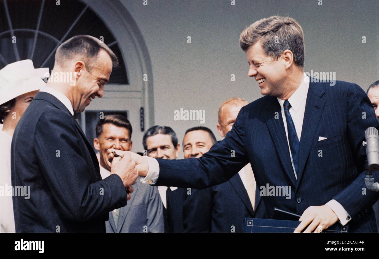 Alan Shepard – einer der ersten sieben Astronauten der NASA – wurde der erste Amerikaner im All. Präsident John F. Kennedy, rechts, verleiht am 8. Mai 1961 im Weißen Haus die Distinguished Service Medal der NASA an Astronaut Shepard bei einer Zeremonie im Rosengarten. Im Hintergrund sind die anderen Mitglieder der Mercury Seven, die ursprünglichen Astronauten der NASA. Stockfoto