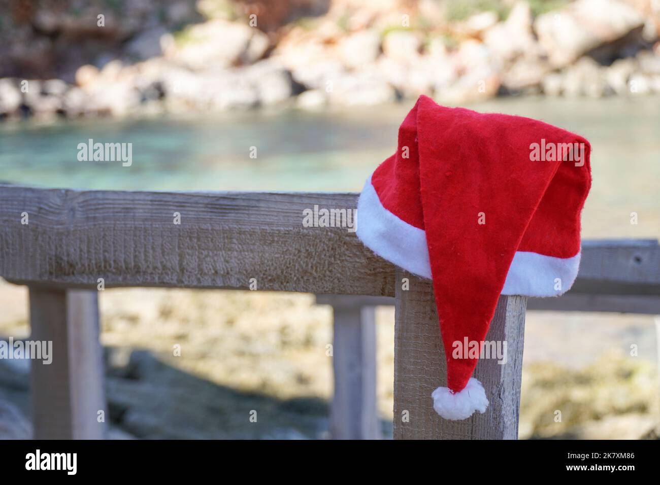 Der Hut des Weihnachtsmanns hängt an einem Stock im Meer. Weihnachten und Neujahr. Stockfoto