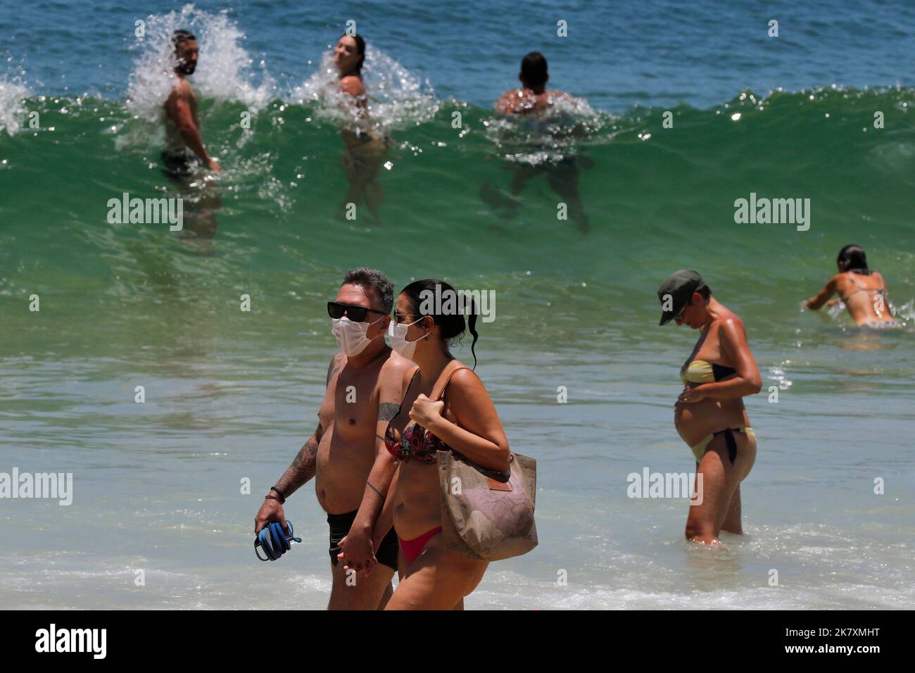 Pärchen trägt Covid-19 Gesichtsmaske am Strand von Cocoaba. Strandgänger sonnen sich am Wochenende in der Nähe der Küste Stockfoto
