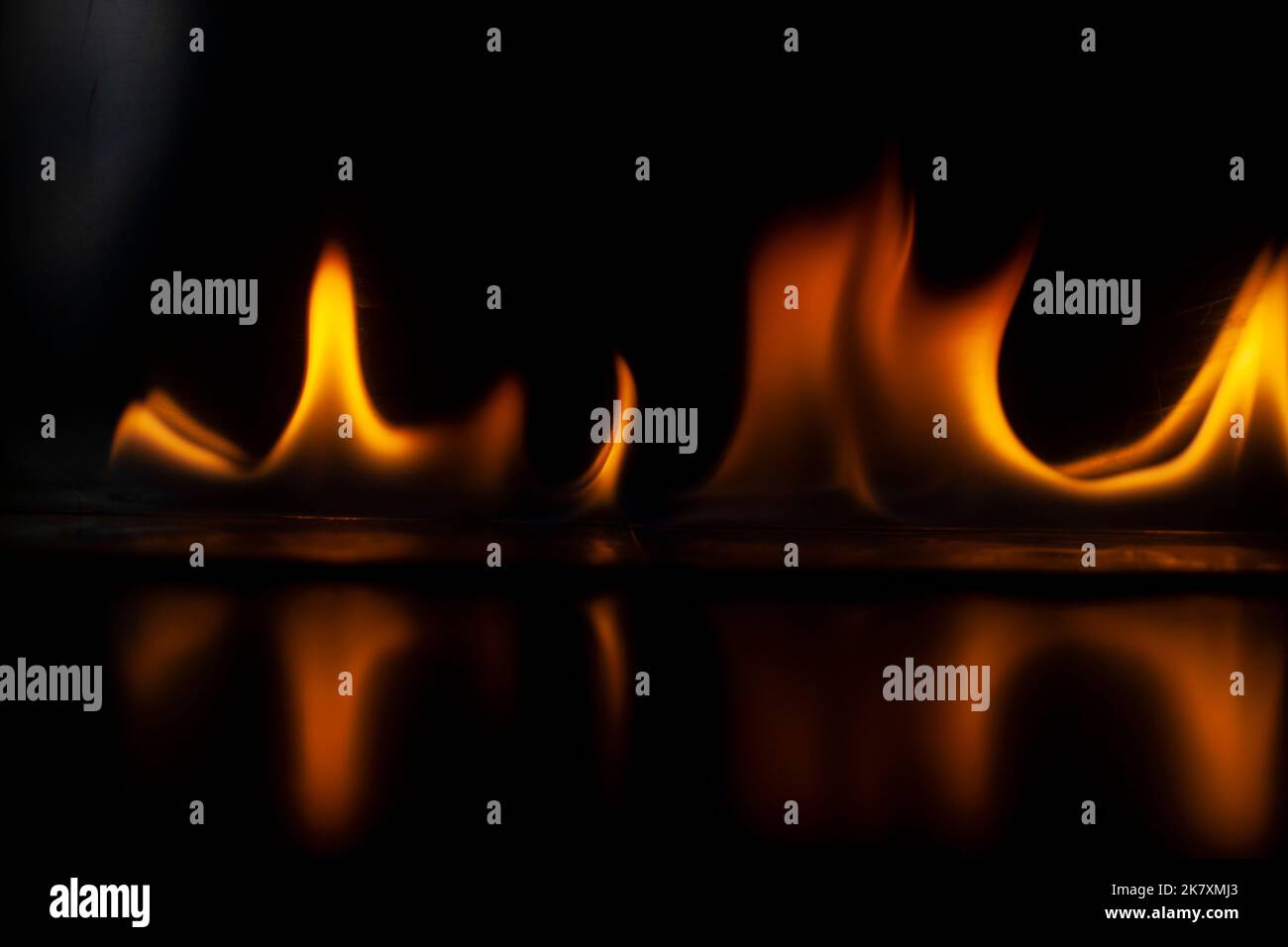 Flammen im Dunkeln. Feuerzunge. Entzündung von Alkohol. Brennender Alkohol auf schwarzem Hintergrund. Erhitzen von Teilen. Stockfoto