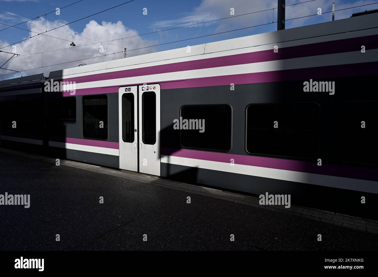 Bus am Bahnsteig im Sonnenlicht Stockfoto