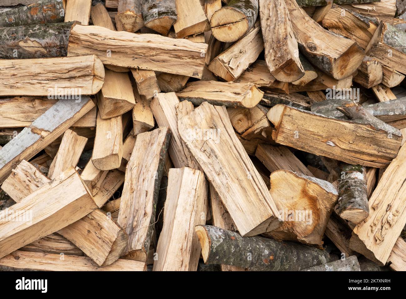Gesägtes und gehacktes Brennholz für die Beheizung in der kalten Jahreszeit. Energie, Energiekrise, Wärme, Brennstoff. Selektiver Fokus, Hintergrund. Stockfoto