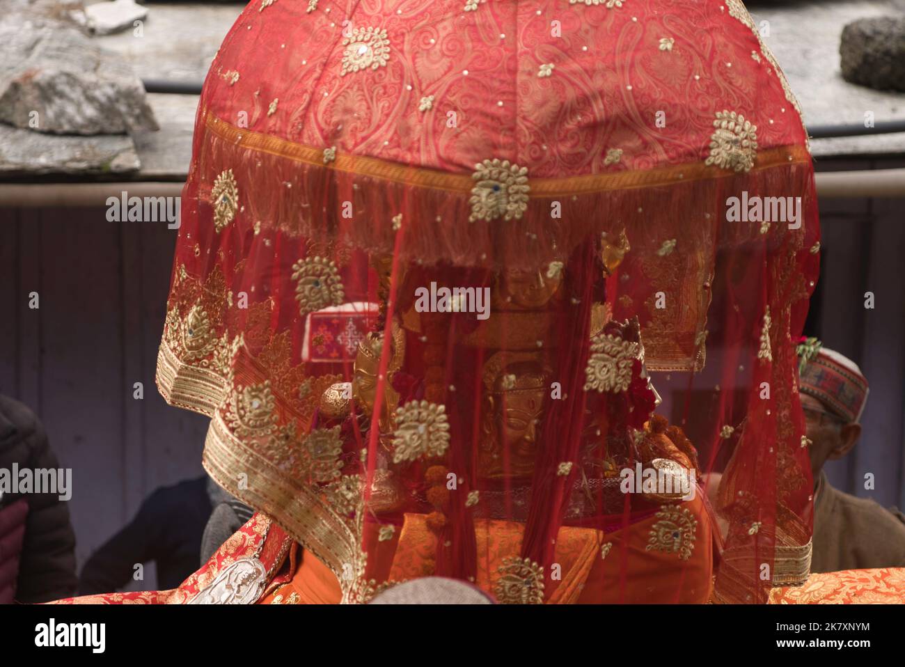 Nahaufnahme der Berggottheit Devta Goddess, die in ihrem Palanquin saß, mit einem roten Tuch, das sie bedeckte Stockfoto