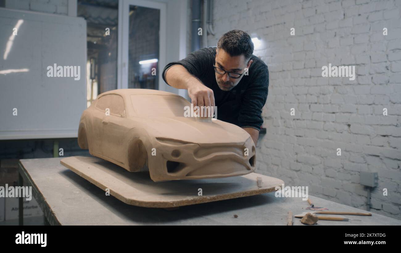 Der leitende Automobildesigner modelliert das aus Lehm gefertigte