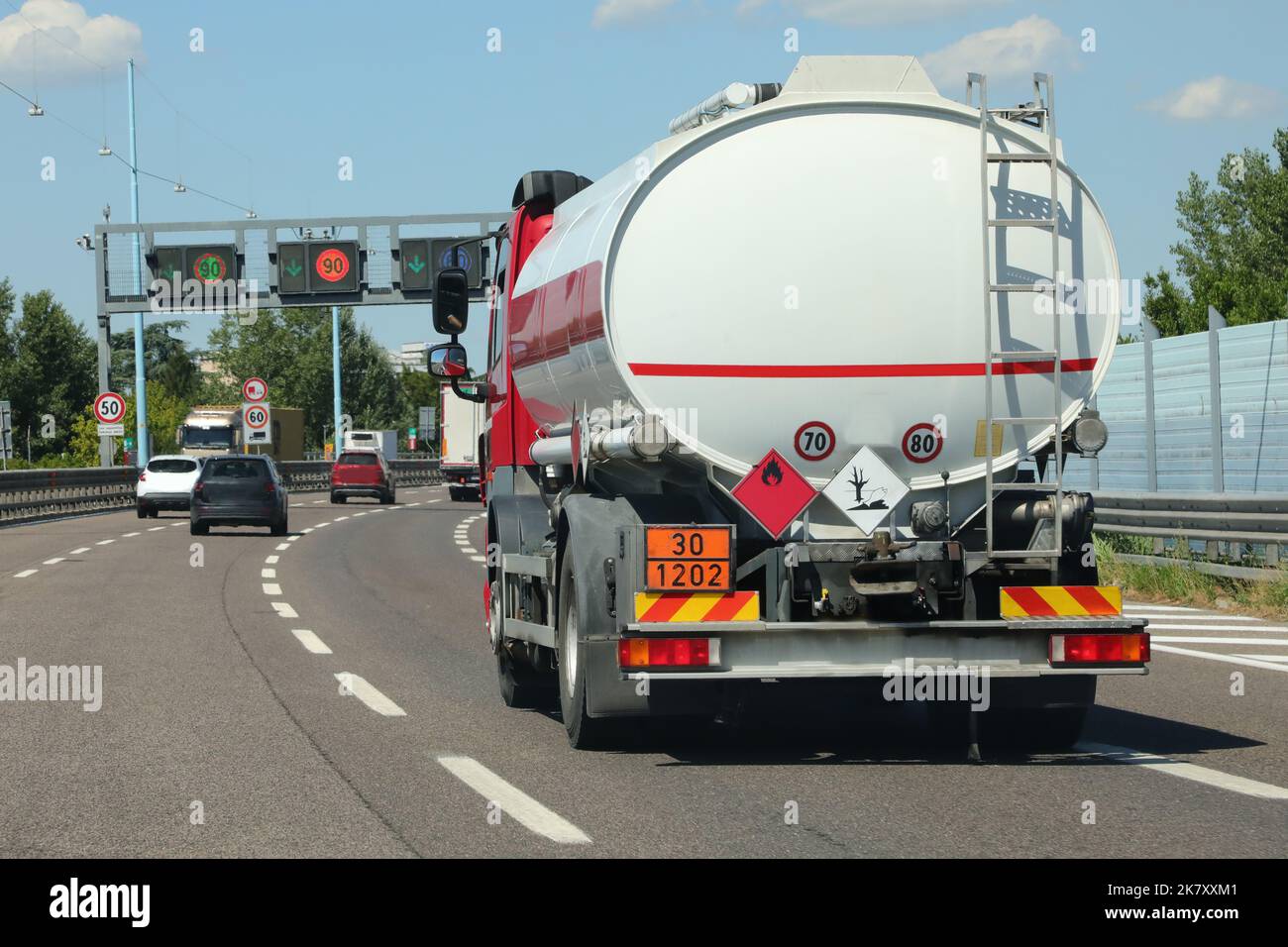 Tankwagen fährt schnell mit fossilen Brennstoffen auf der verkehrsreichen Straße Stockfoto