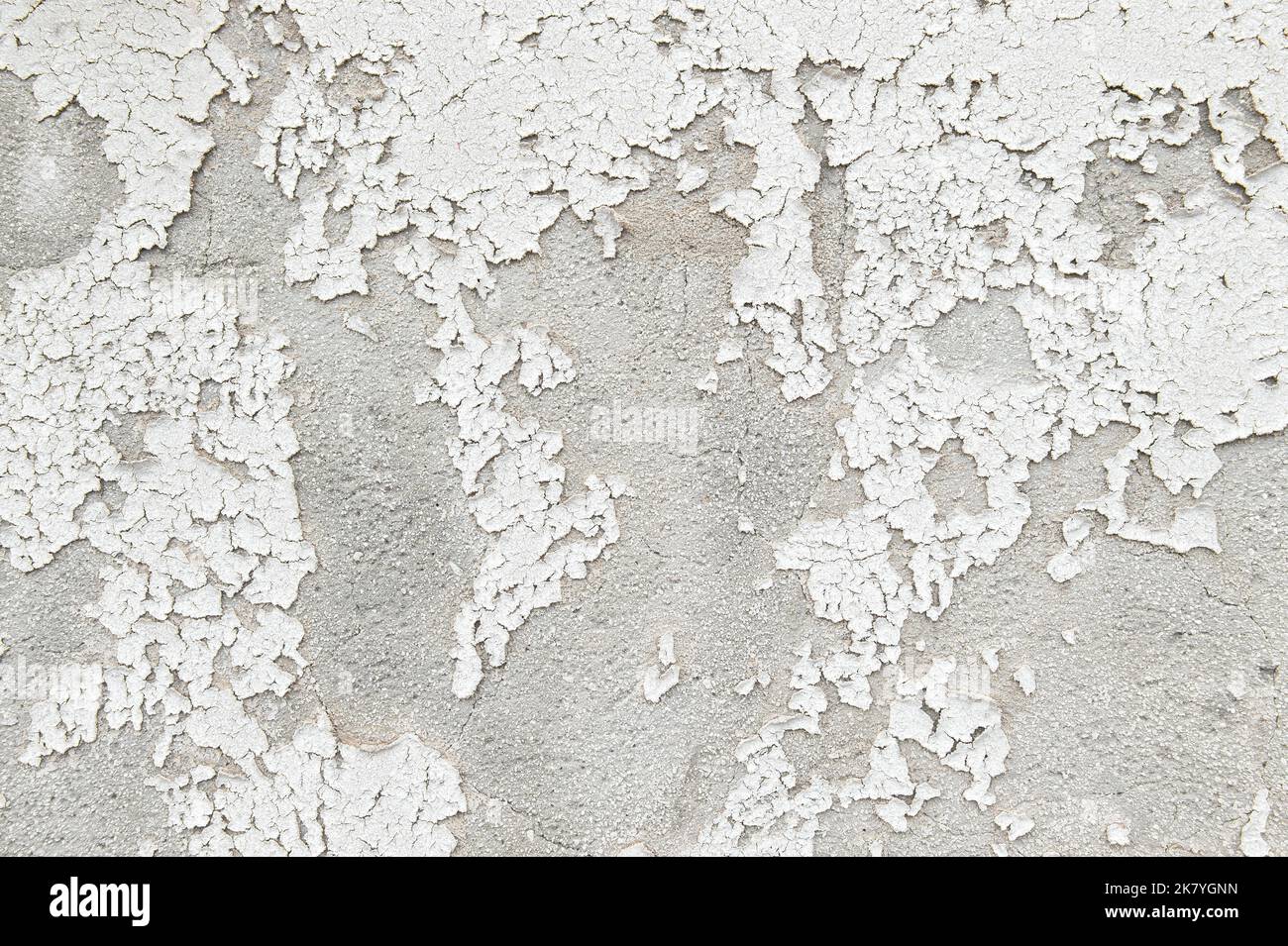 Weiße Zementwandstruktur mit Rissen. Rissiger Steinhintergrund Stockfoto