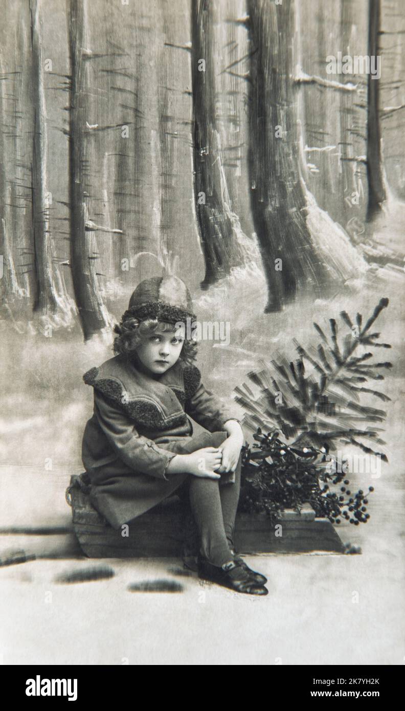 Kleines Mädchen mit Weihnachtsbaum. Vintage-Postkartenbild mit Original-Filmkörnung Stockfoto